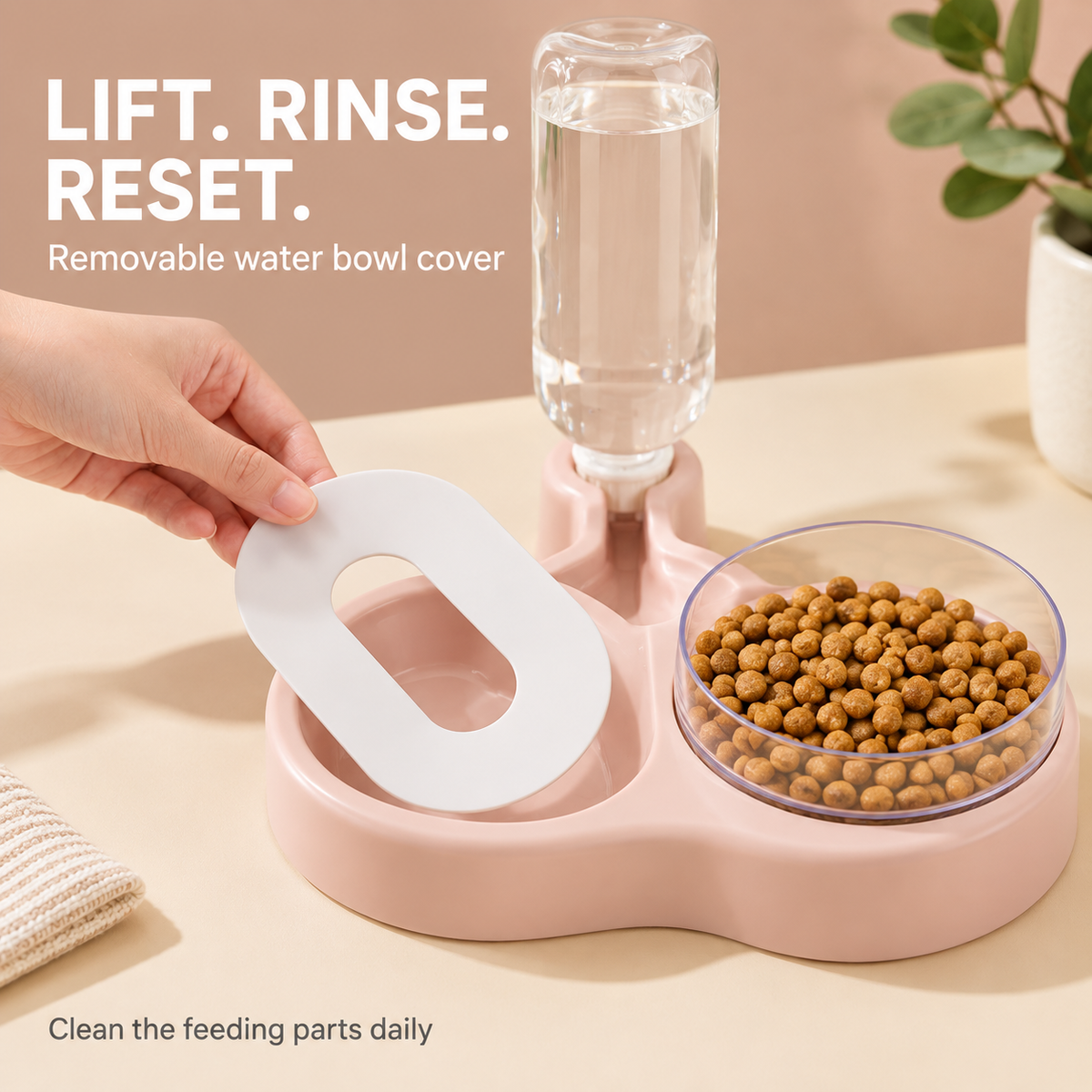 A hand lifting the white oval drinking cover from the pink water tray for cleaning