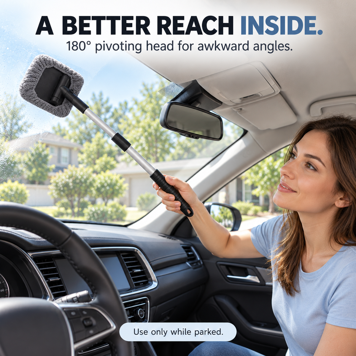 A woman using the extendable microfiber cleaner on the inside windshield of a parked car.